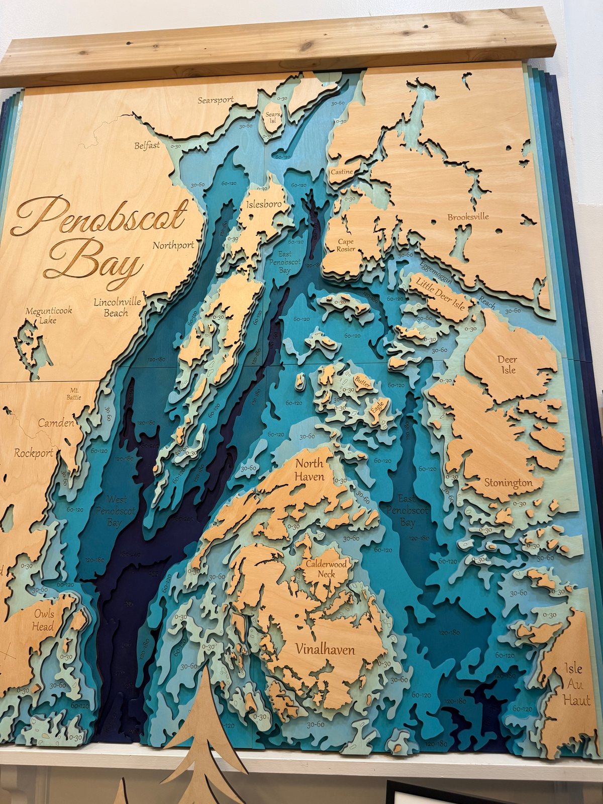 Penobscot Bay in layered wood, with teal water depths and engraved island names